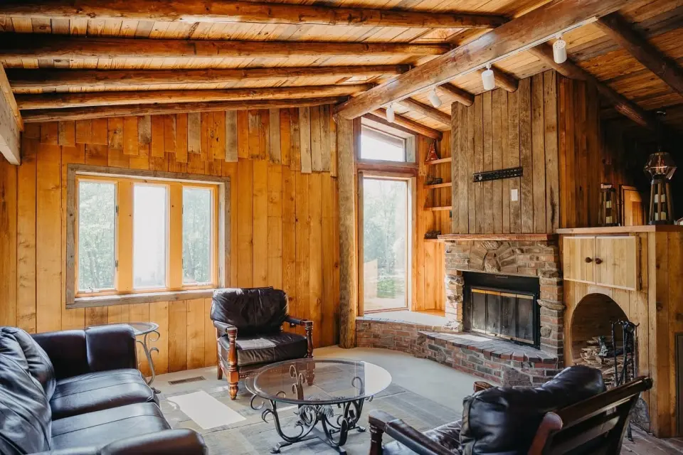 Lodge lounge with leather chairs and a stone fireplace
