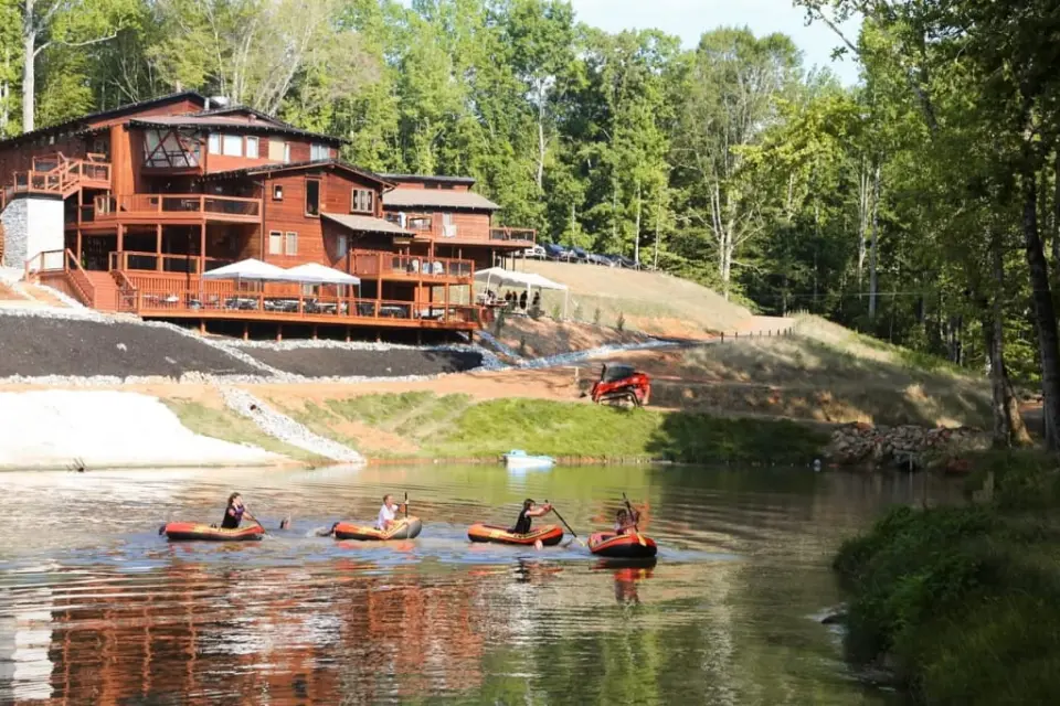 Kayaks on the stream-fed pond at Old Mill Village with the lodge behind